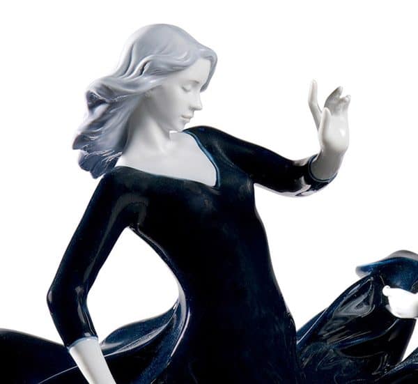 Glossy porcelain figurine of two beautiful women with long and voluptuous dresses of a deep blue degraded color. Close up of second female following on close behind