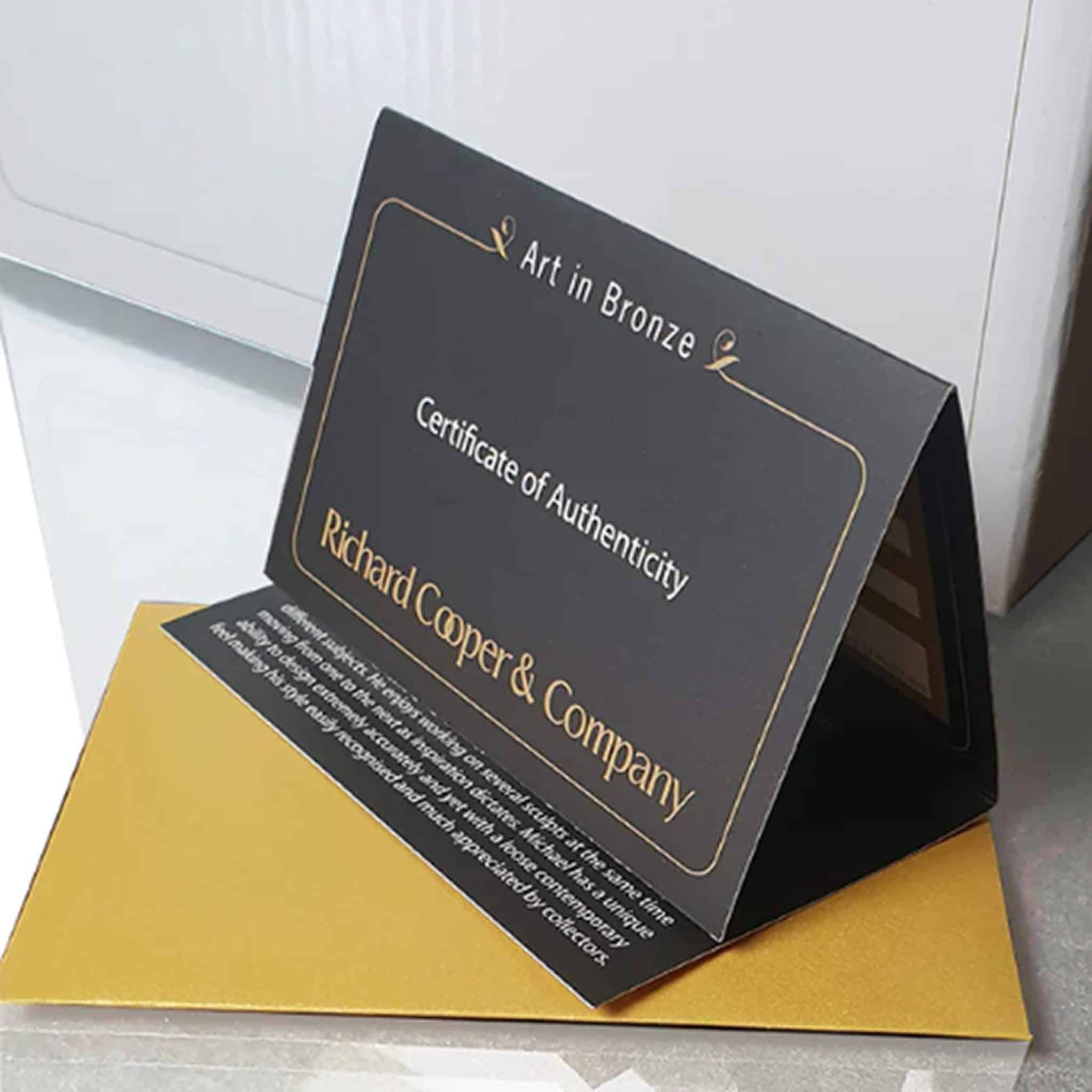 An official Richard Cooper Bronze gold-embossed limited edition certificate of authenticity resting on a premium gold gift envelope.
