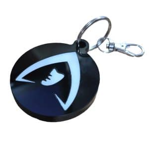 Double-layered black and white acrylic Traitors monk head keyring isolated on a clean white studio background
