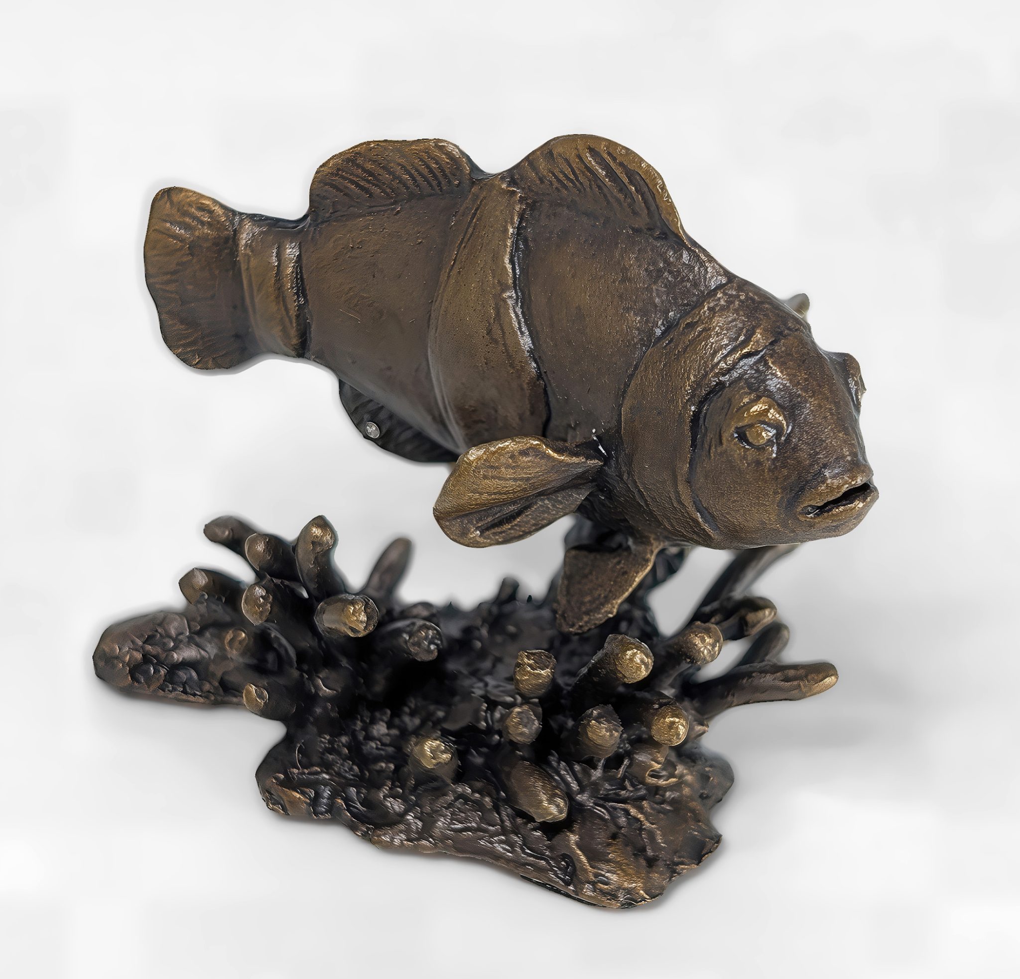 Solid bronze clownfish sculpture swimming over a coral reef base with distinct white band details and rich patina by Marquise Jewellery