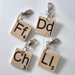 Handmade beige Welsh Scrabble Letter Keyrings with black engraved Ff, Dd, Ch, and Ll tiles as end of term gifts for Welsh teachers